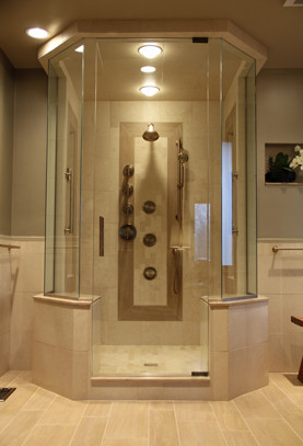 Frameless glass shower door enclosing his and her steam shower